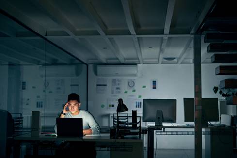 Man in dark office alone - Overtime Violations